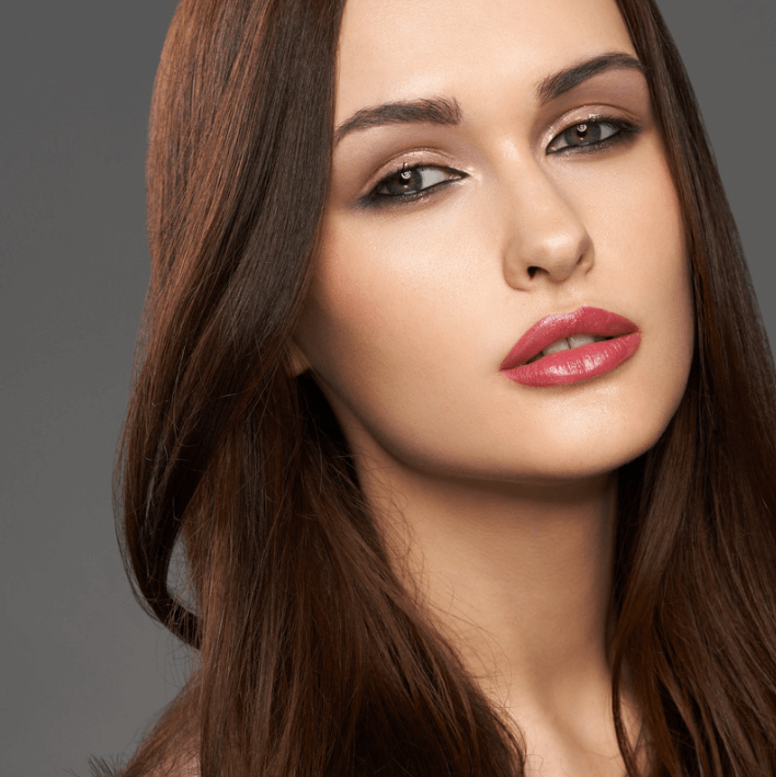 Model showcasing Luxe Lippencrème on smooth, glossy lips for a polished beauty look.