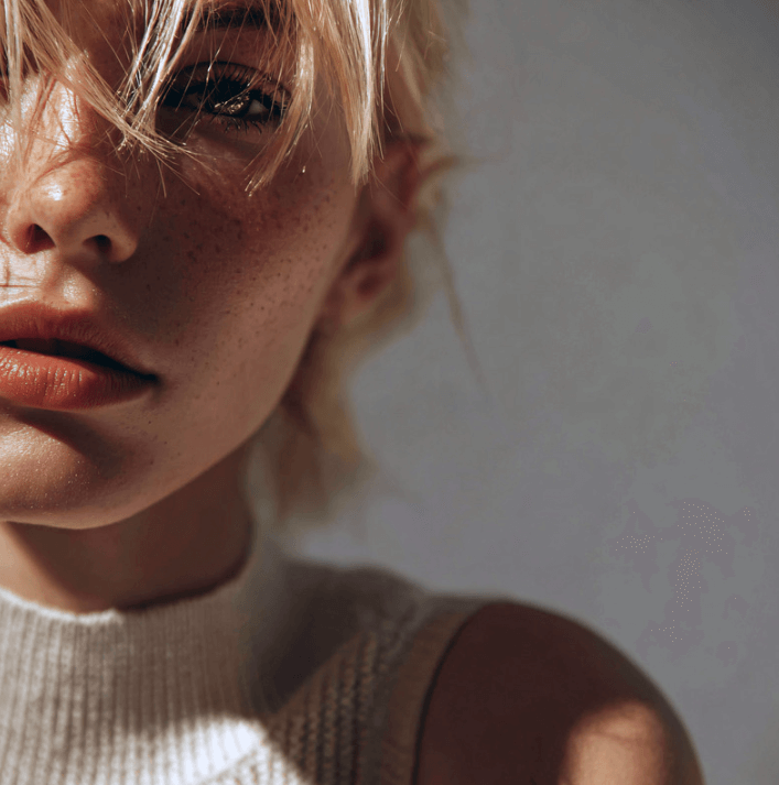 Close-up of a woman with clear skin and subtle freckles, showcasing a natural beauty look.